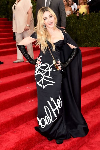Madonna wearing a printed black dress with cape and gloves