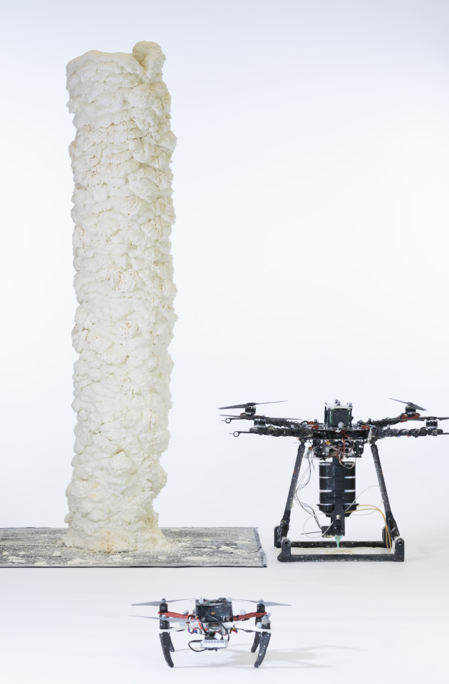 Photo of the two drones alongside a structure, which is taller than a human