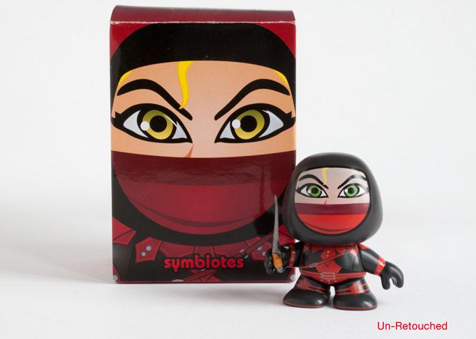 Photo of red figurine product and packaging before retouching