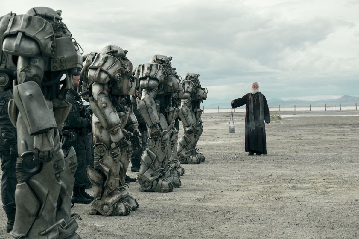A priest of the Brotherhood of Steel blessing some brothers in their power armor