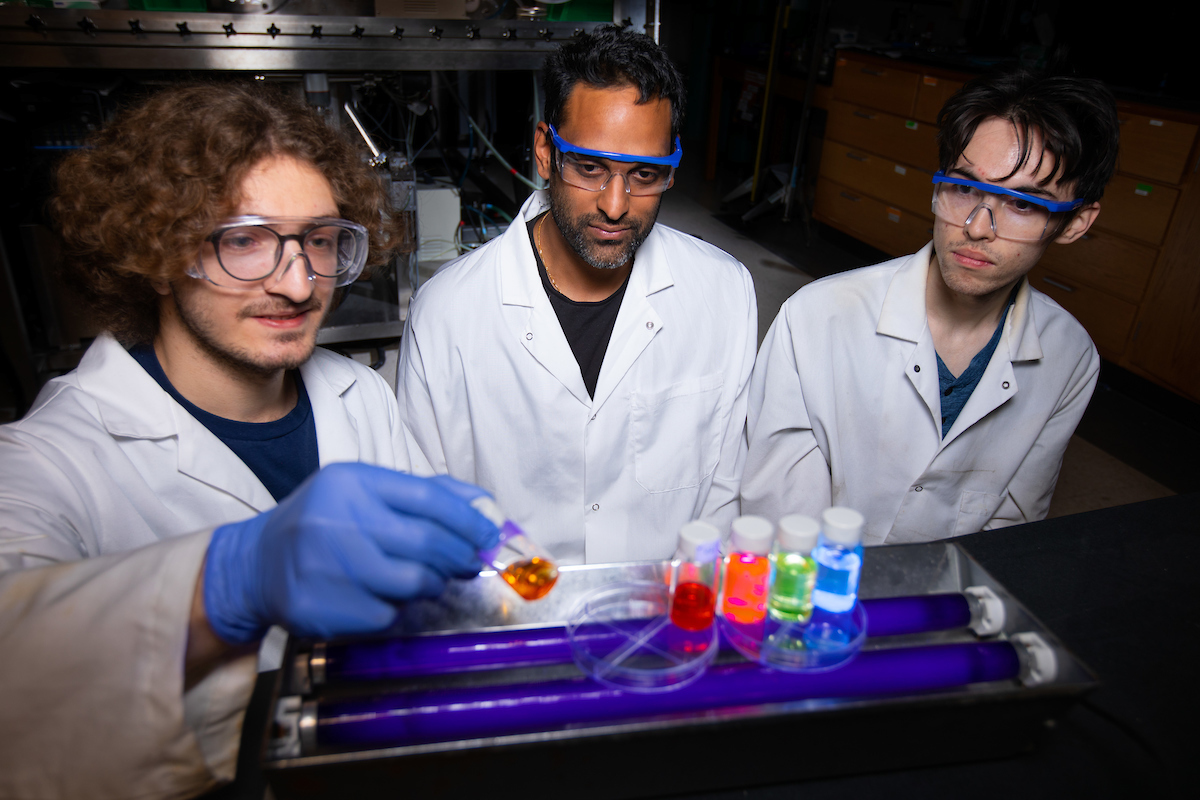 Matthew Panthani, center, with doctoral students Maharram Jabrayilov, left, and Andrew Tan, with vials full of silicon quantum dots, nanoparticles with properties determined by their sizes..