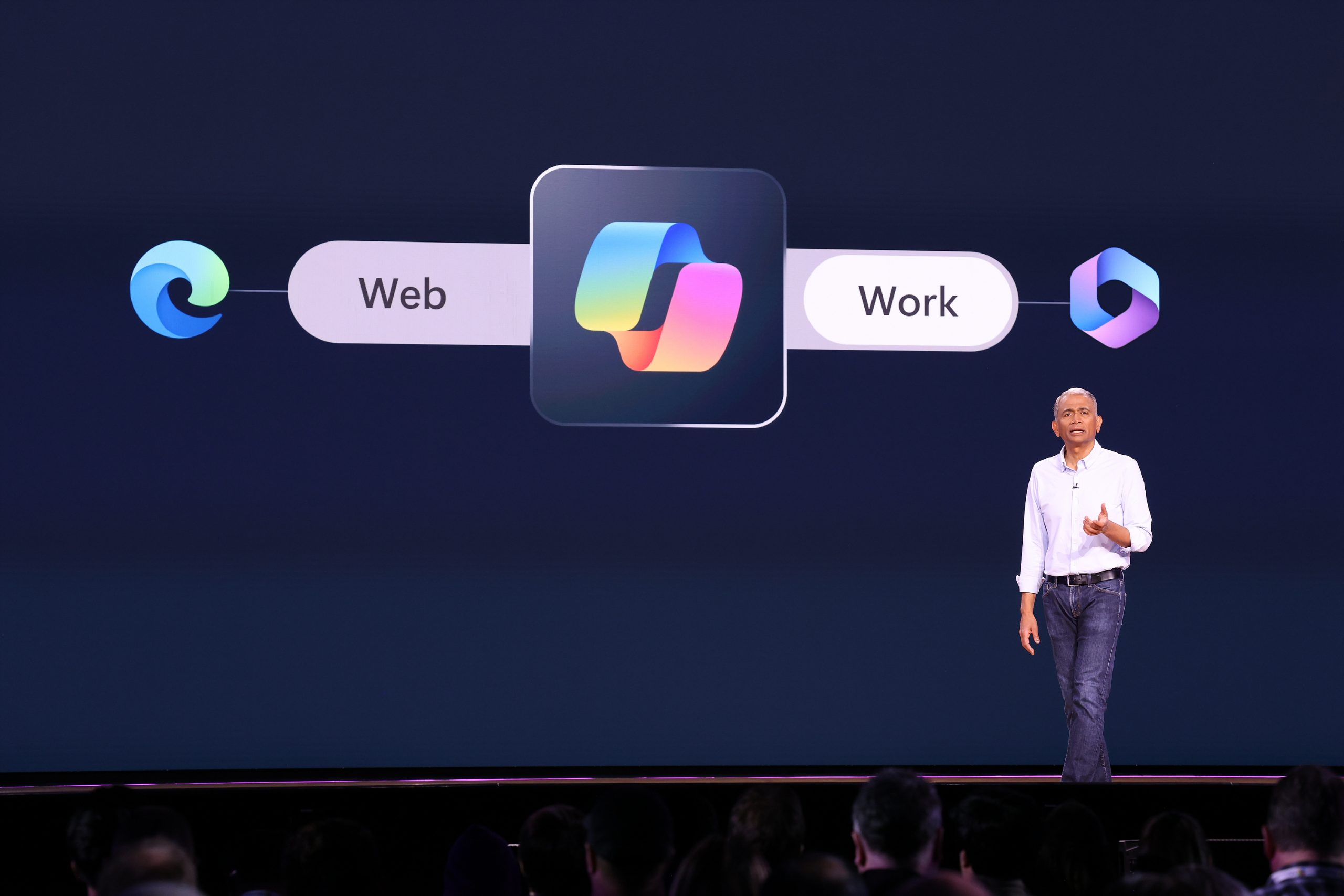 A man standing on stage with the Copilot logo and the words 